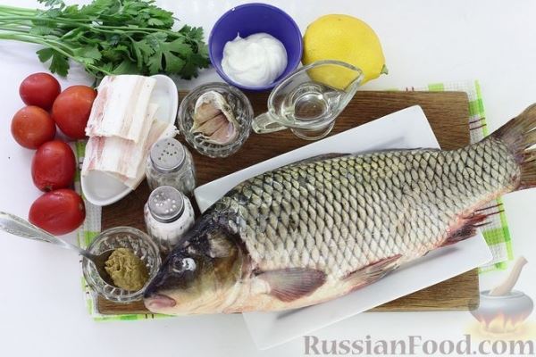 Запечённый карп, фаршированный помидорами, чесноком и зеленью